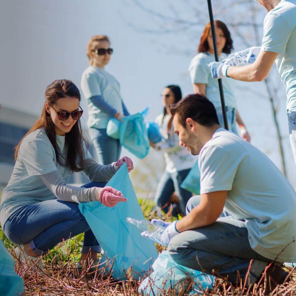 Volunteers actively collecting litter in a park, promoting community cleanliness and environmental stewardship.