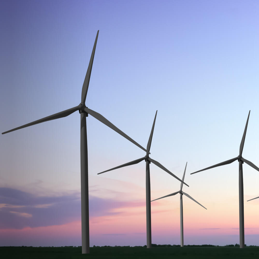 Wind turbines silhouetted against a vibrant sunset